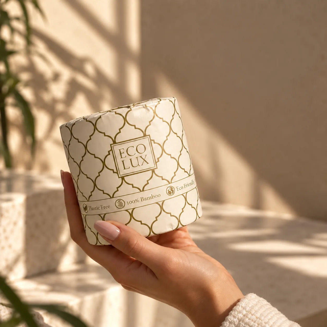 A hand holding up a wrapped Eco Lux roll in warm afternoon light